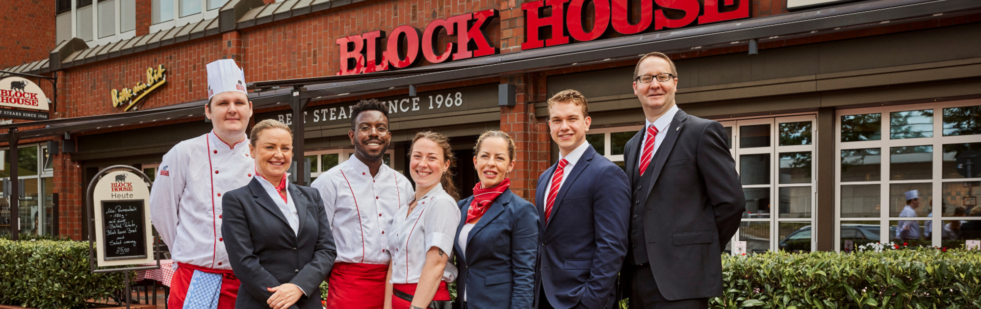 Mitarbeitende aus Küche und Service vor einem BLOCK HOUSE Restaurant