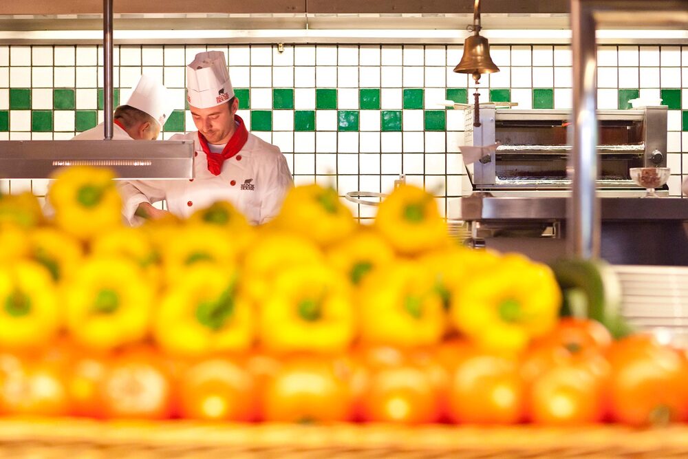 Bunte Paprikas in der Küche des BLOCK HOUSE Restaurants in Hamburg Volkdorf, im Hintergrund sind Griller bei der Arbeit