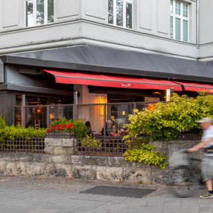 Terrasse des BLOCK HOUSE Berlin Theodor-Heuss-Platz mit Tischen und Gästen vor dem Steakhouse